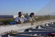 Netting being installed over commercial HVAC units